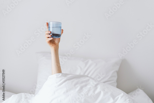 Woman holding glass of water after awakeness