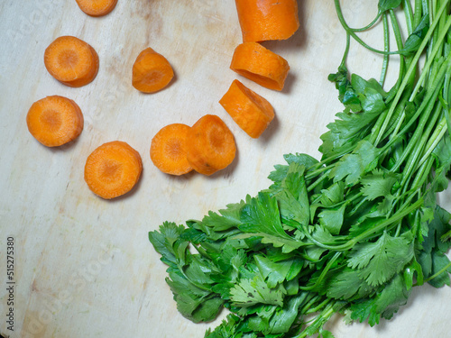 Sliced carrots on the table. Greens . Soup preparation. Soup ingredient Root crop on a cutting board.