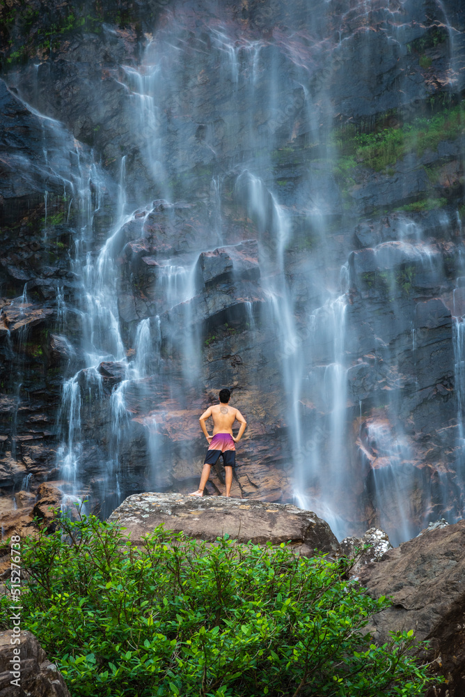 Fototapeta premium Beautiful view to man enjoying big natural wild waterfall