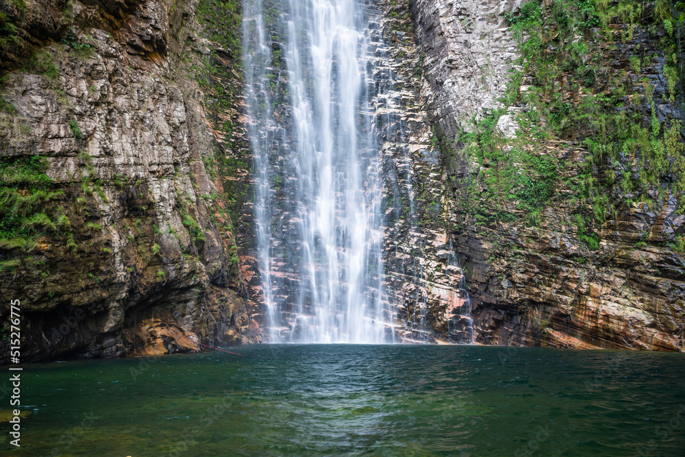 Fototapeta premium Beautiful view to big wild rocky waterfall on green area