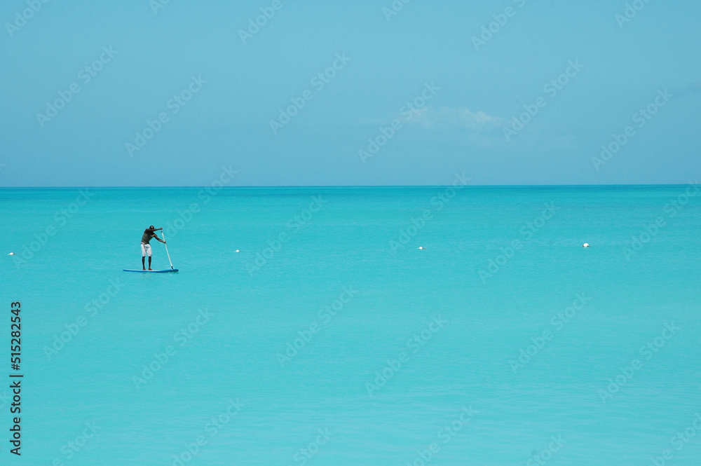 A paddle boarder on the calm Caribbean Ocean