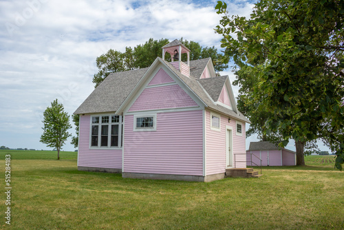 Close up view of an old pink country school house exterior with bell tower, built in the 1800’s in the midwestern USA © Cynthia