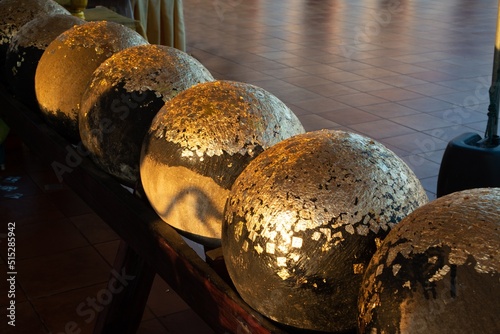 Gold foils pasted on the surface of Luuk Nimit round stones for buried in the ground to mark the sacred limits of a temple for the consecration temple ceremony called Fang Luuk Nimit. photo