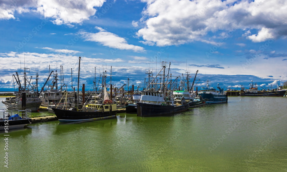  
Fishing Boats in Marina and a cloudy sky. This marina is located in the Steveston area of Richmond. The fishing village formed in this place was the first settlement on the territory of  Richmond 

