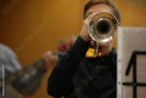 A musician with a trumpet plays a concert a view of the bell of a musical instrument a close-up image of a blowing trumpeter in front