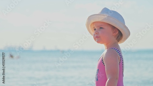 Adorable Caucasian Baby Girl Toddler Playing on Beach during Hot Sunny Afternoon