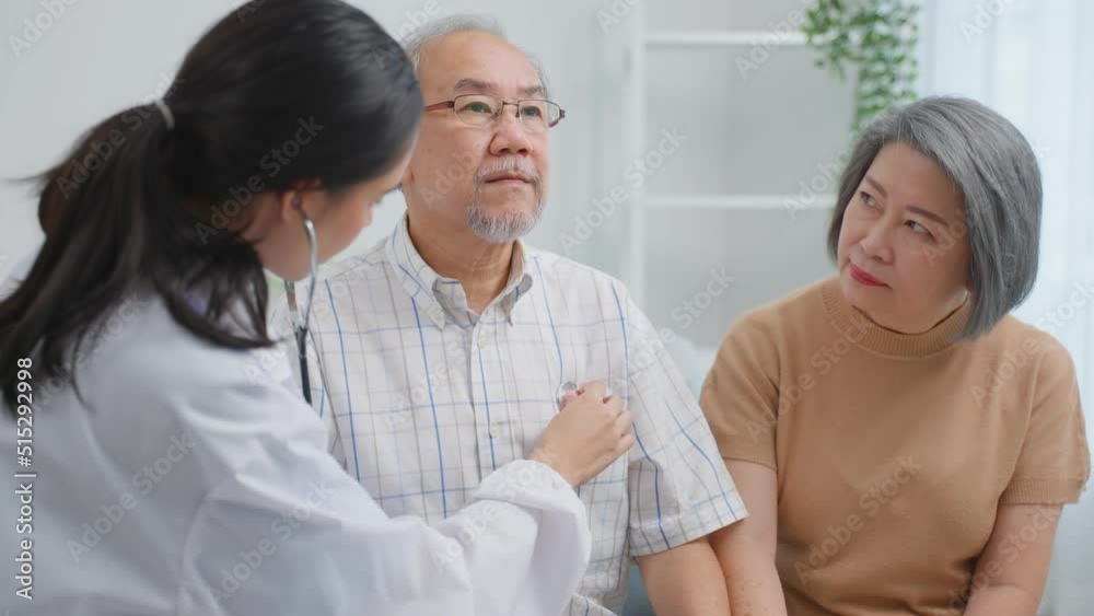 Asian caregiver measure heart rate by stethoscope on senior patient. Asian caregiver measure heart rate by stethoscope on senior patient.