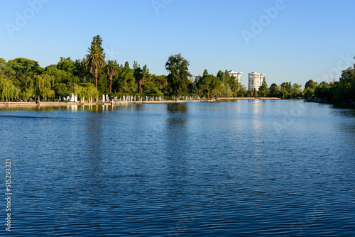 Paisaje de lago y parque con bosque al fondo. Ciudad de Mendoza. Argentina.