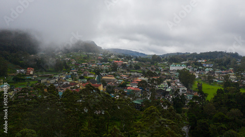 Aerial view of city of Nuwara Eliya is covered with clouds among green hills and mountains. Sri Lanka.