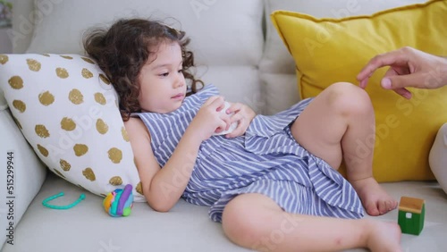 cute caucasian girl daughter laying relax playing tikkle game with her love father on sofa in living room at home,sweet family sunnday weekend morning game dad is play fun with laugh smile of her girl photo