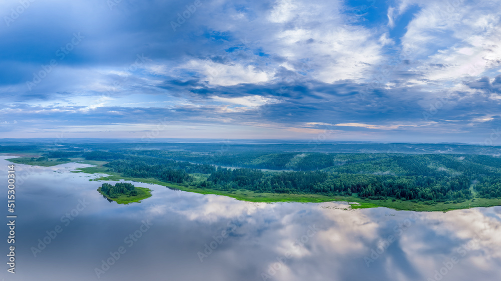 Obraz premium Big lake and island with green shores with morning fog in dawn, aerial landscape. Recreation concept. Aerial view