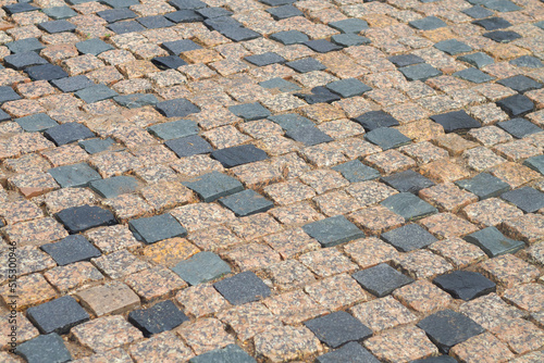New cobblestone pavement made of brown and black granite stones