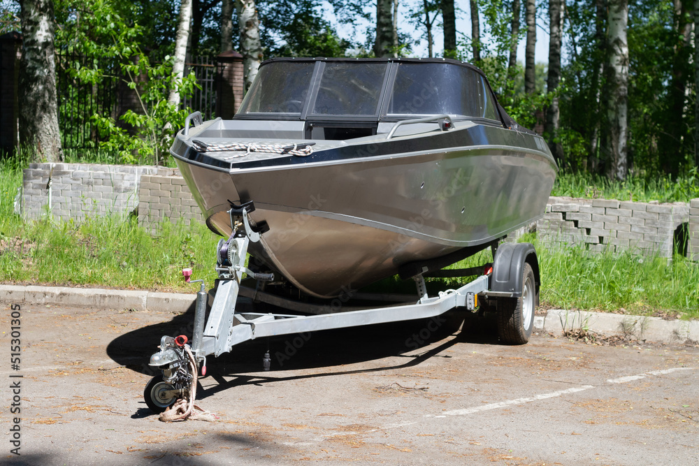 A boat or a boat with a motor on a trailer with wheels for transportation by car with a trailer