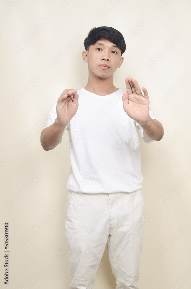 portrait of asian man wearing white t-shirt denying something. portrait of asian man wearing white t-shirt denying something.