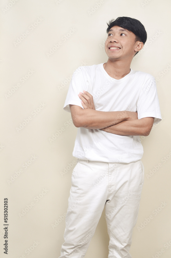 portrait of handsome asian young man smiling while looking sideways in empty space portrait of handsome asian young man smiling while looking sideways in empty space