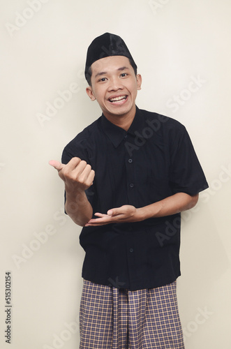 Asian Muslim youth standing and posing greeting with friendly smile photo