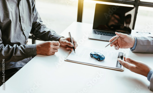 Closeup of Asian business man signing car insurance document or lease paper contract or agreement. photo