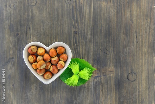 Fresh unshelled hazelnuts in a heart shaped dish
