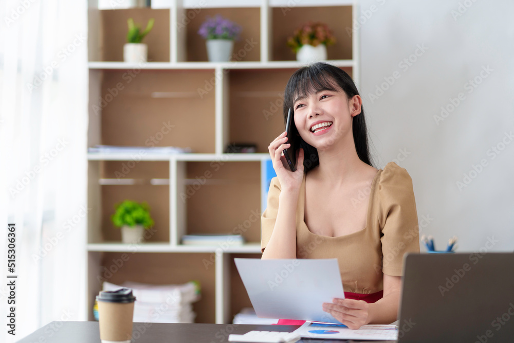 Asian businesswoman talking on the phone with customer in the office. Asian businesswoman talking on the phone with customer in the office.
