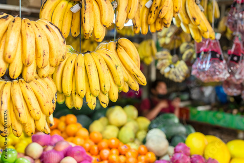 Hanging Lacatan Bananas and other tropical fruits for sale at a market stand. photo