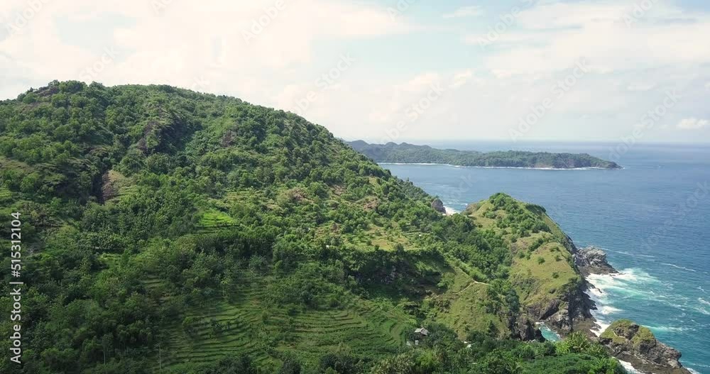 hill with green trees and cliff which bordering with sea in Bukit Pengilon, Yogyakarta, Indonesia. a must-visit tourist location in Gunungkidul. hills and sea stock footage. hill with green trees and cliff which bordering with sea in Bukit Pengilon, Yogyakarta, Indonesia. a must-visit tourist location in Gunungkidul. hills and sea stock footage.