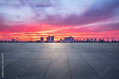 Empty square floor and city skyline with modern buildings in Hangzhou at sunrise, China.
