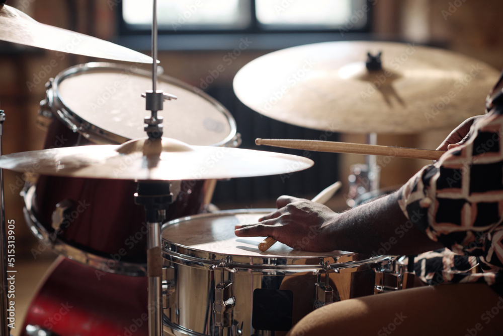 Close-up of African drummer playing rock music on drums set with sticks Close-up of African drummer playing rock music on drums set with sticks