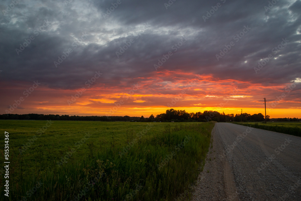 Scenic rural landscape with rural broken dirt road at sunset.