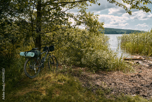 Fototapeta Naklejka Na Ścianę i Meble -  A gravel bicycle with camping equipment for outdoor leisure activities. Summer adventures on the bike. Two travel mats on the front rack of the cycle.