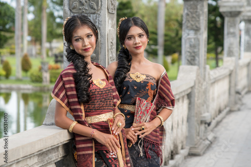 Beautiful girls in Balinese traditional dress with fan, Taman Ujung Bali.
