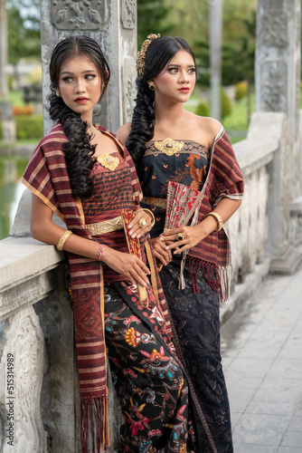 Beautiful girls in Balinese traditional dress with fan, Taman Ujung Bali.