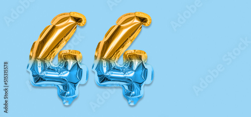 Rainbow foil balloon number, digit forty four on a blue background. Birthday greeting card with inscription 44. Top view. Numerical digit. Celebration event, template. Banner photo