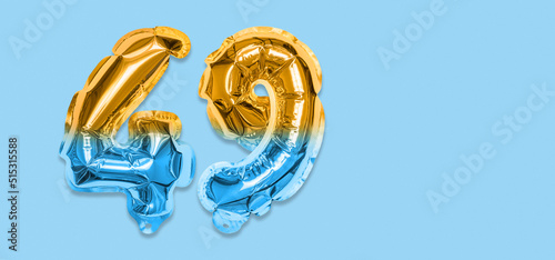 Rainbow foil balloon number, digit forty nine on a blue background. Birthday greeting card with inscription 49. Top view. Numerical digit. Celebration event, template. Banner photo