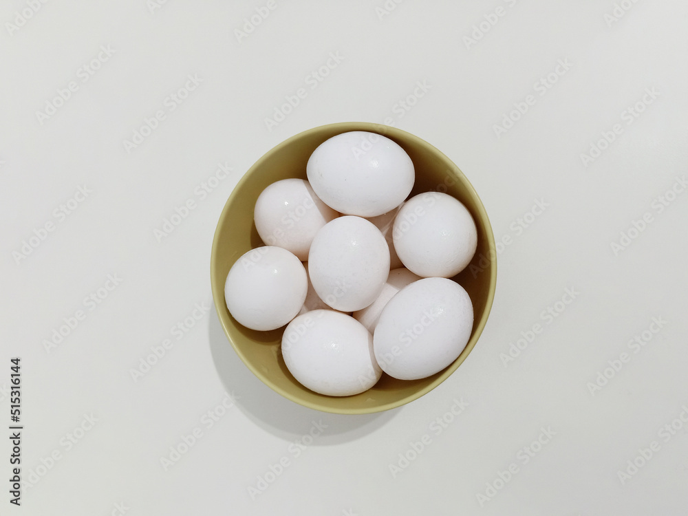 Top view, Many eggs, a bowl full of white eggs on a white background Top view, Many eggs, a bowl full of white eggs on a white background