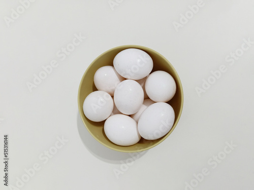 Top view, Many eggs, a bowl full of white eggs on a white background