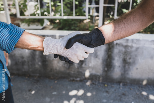 gloved handshake. Wearing gloves to avoid monkeypox and diseases. gloved hands hold.