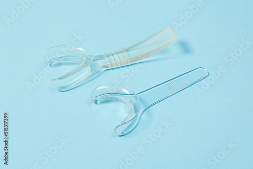 set of several Retractor Dental lip retractor Access to the oral cavity. Wide mouth opening for a dental procedure on a clean blue background