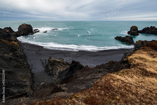 Elevated view of Dritvík Bay, Snæfellsnes, Iceland. Panoramic landscape scenery with beautiful black lava beach and the various basalt rock formations in this beautiful cove near Djúpalónssandur. photo