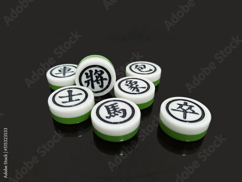 There are Chinese chess scattered on a black background, showing Black main players: General, Advisors, Elephant, Rooks, Cannons, Horses and Soldiers.