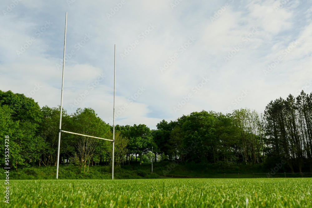 Tall goal post for rugby, hurling and camogie training. Popular active game in Ireland. National sport. Park with sport field. Low angle shot.