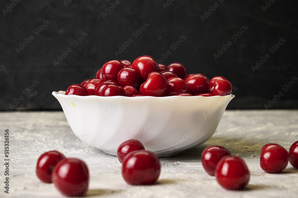 red ripe cherries in a white plate on the table red ripe cherries in a white plate on the table