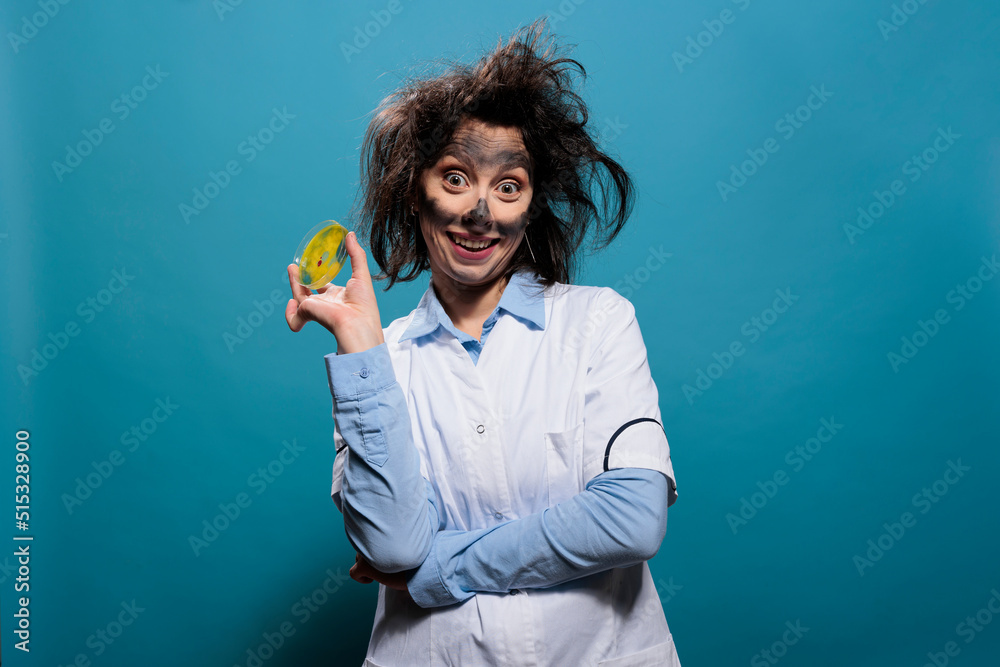Crazy chemist having petri dish glass plate filled with toxic biological waste material while smiling dreadful at camera. Mad amusing scientist grinning creepy while holding glass plate sample. Crazy chemist having petri dish glass plate filled with toxic biological waste material while smiling dreadful at camera. Mad amusing scientist grinning creepy while holding glass plate sample.