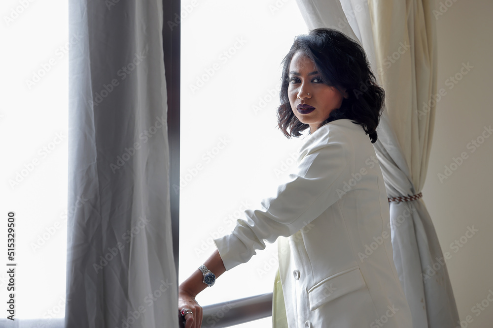 Asian female dark skinned Indian Bengali subcontinent at home office table chair business work study look smile emotion confident stand next to window Asian female dark skinned Indian Bengali subcontinent at home office table chair business work study look smile emotion confident stand next to window