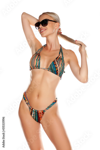 Young blonde woman in bikini and sunglasses, isolated on white. © Jasmina