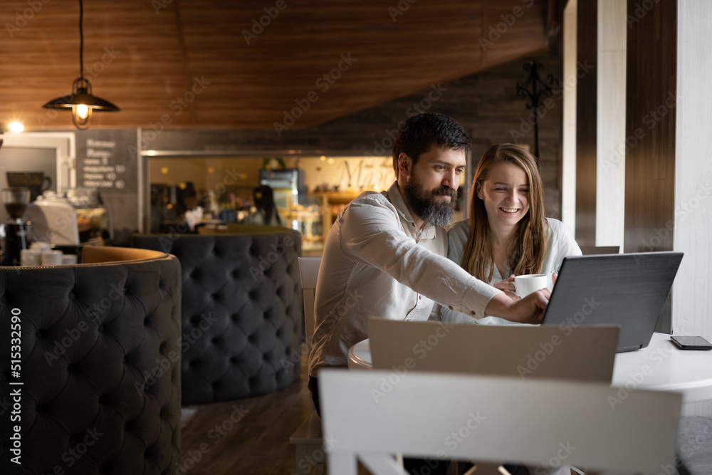 Two smiling creative workers discussing a project during a meeting in a cafe Two smiling creative workers discussing a project during a meeting in a cafe