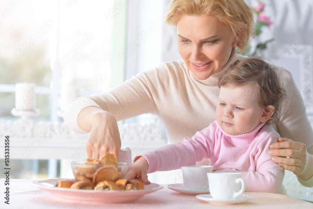 Mom and daughter eat breakfast and drink tea Mom and daughter eat breakfast and drink tea