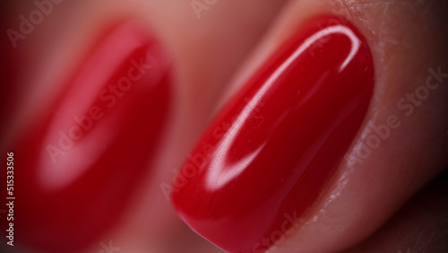Female fingers with red bright glossy varnish