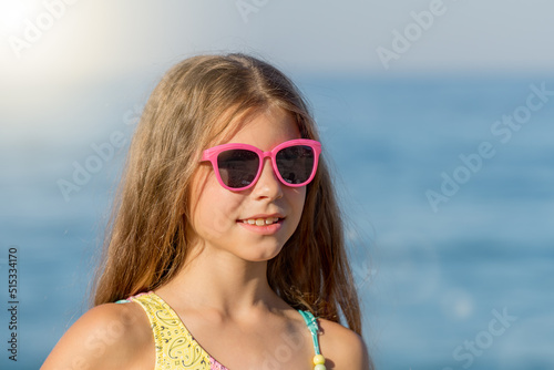 Close-up portrait of a girl in a bathing suit and glasses. © Svetlana Rey