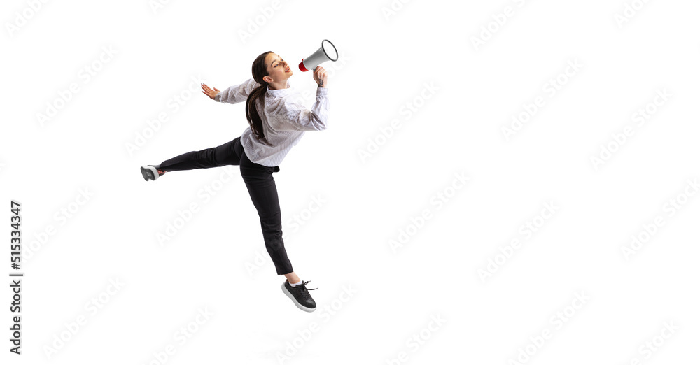Portrait of young woman, employee in official outfit shouting in megaphone isolated over white studio background