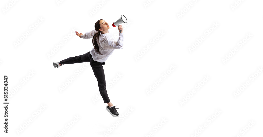 Portrait of young woman, employee in official outfit shouting in megaphone isolated over white studio background